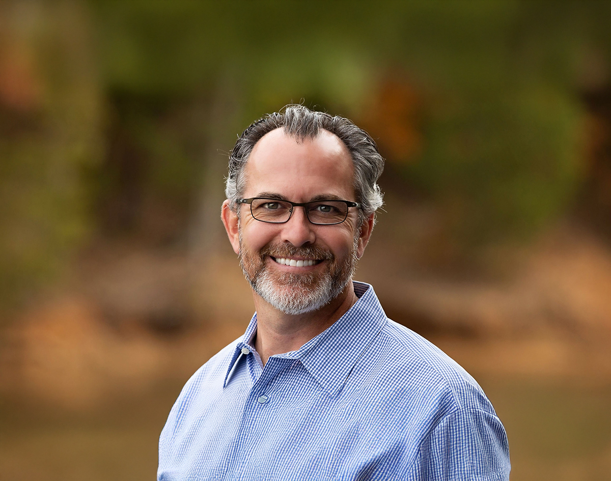 Michael-Riordan-DMD-blue-shirt-trees-in-background