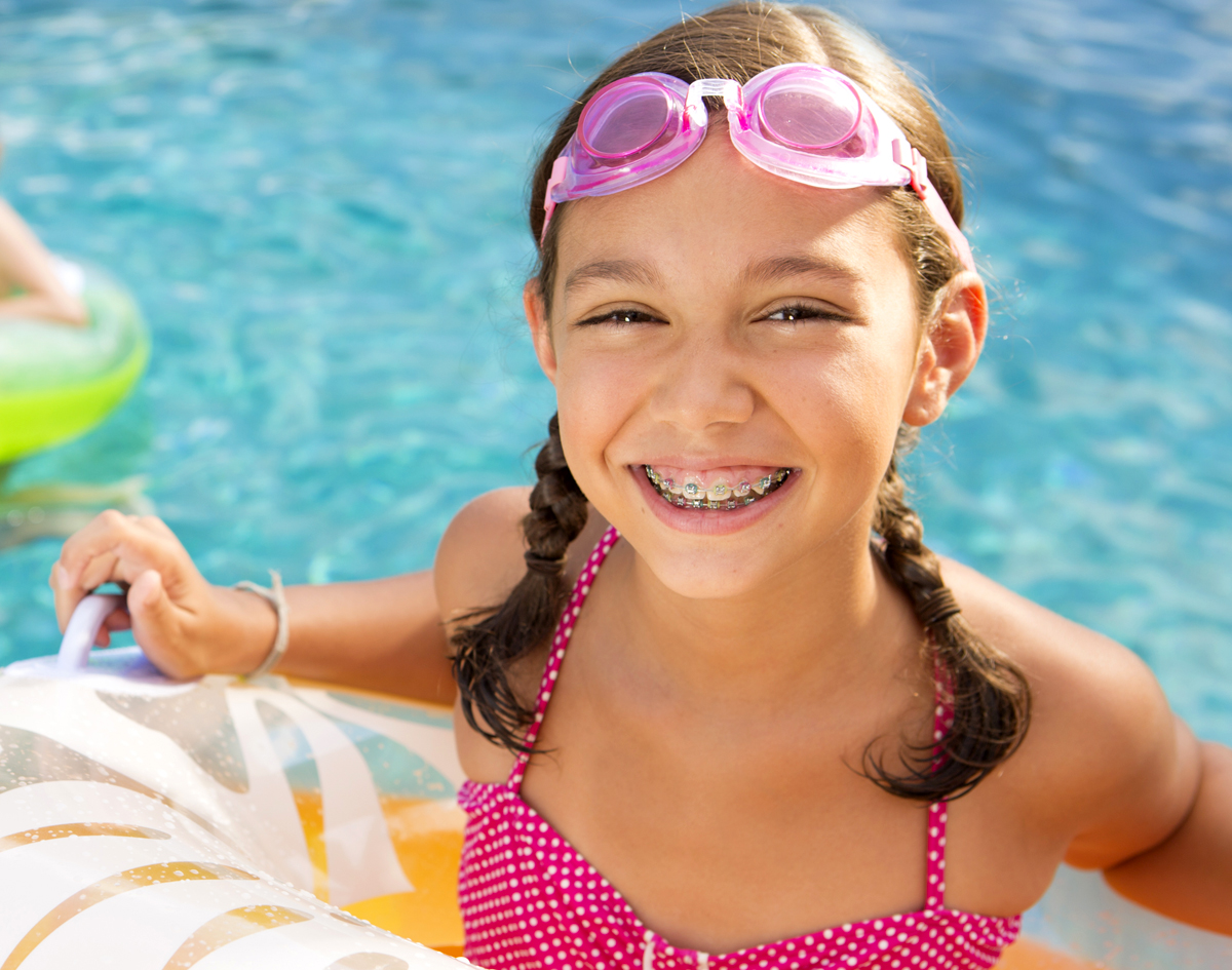 Michael-Riordan-DMD-young-girl-in-pool-with-braces-smiling