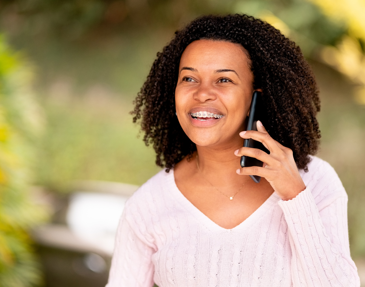 Michael-Riordan-Orthodontics-woman-with-braces-on-phone
